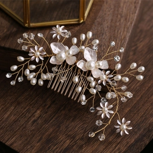 Eleganter Braut-Haarkamm mit Perlen, Kristallen und Goldblumen auf Holzuntergrund
