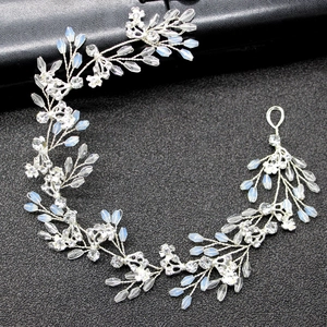 Handmade bridal hair vine with silver wire, crystals, and opal beads on black background