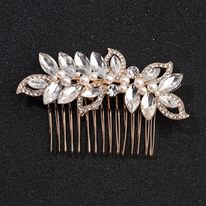 Détail du peigne à cheveux de mariée avec feuilles dorées, perles blanches et strass brillants