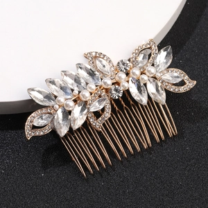 Détail d'un peigne à cheveux doré de mariée avec perles blanches et strass brillants