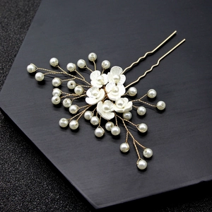 Detail of bridal hair pin with handmade shell flowers and white pearls on gold wire