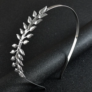 Close-up of elegant silver olive leaf metal headband on minimalist dark background