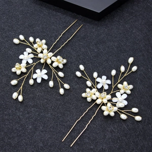 Goldenes Braut-Haarnadel-Set mit weißen Blumen und Perlen auf elegantem schwarzem Grund