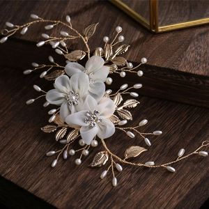 Elegant bridal headpiece with white chiffon flowers, pearls, and gold metal leaves