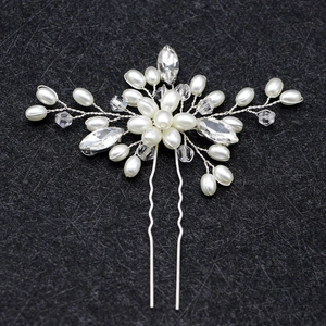 Close-up of bridal U-shaped hair pin with white pearls and clear crystal accents