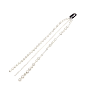 Détail macro d'une pince à cheveux à trois couches de perles avec clip en métal