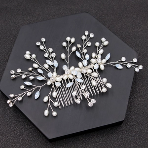 Detailed close-up of bridal hair comb with pearls and opal marquise stones on black base