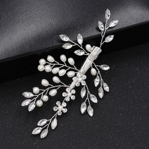 Barrette de mariée argentée avec perles et strass posée sur un coffret noir