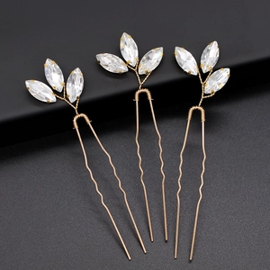 Detailed view of three gold bridal hair pins with marquise cut crystals and wire wrap