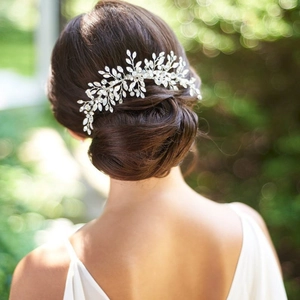 Detail of silver vine bridal hair comb with crystal rhinestones on elegant hair bun