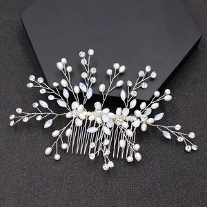 Silver bridal hair comb with pearls, crystals, and blue leaf gems on black background
