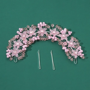 Detail of pink resin flowers and faux pearls on a wedding hair accessory set