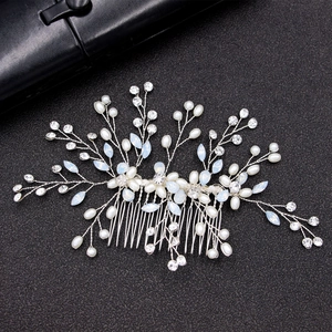 Detail of silver bridal hair comb with pearls, crystals, and blue leaf-shaped stones