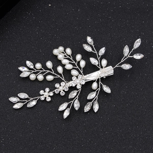 Pince à cheveux de mariée avec perles et strass sur un fond noir texturé