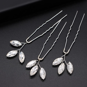 Detailed view of three silver bridal hair pins with marquise-cut crystal leaves on black base