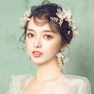 Bridal hair accessory set with white lace flowers, pearls and golden leaves on a model