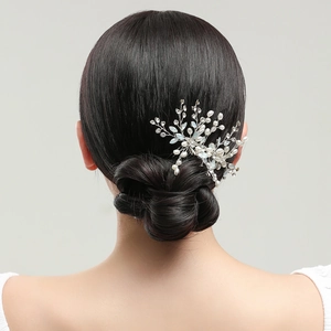 Elegant bridal hair comb with pearls and rhinestones shown on a bride's hairstyle