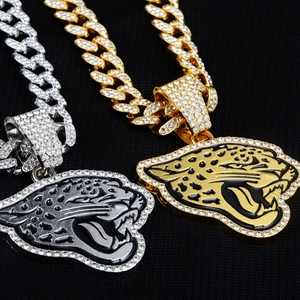 Close-up of gold and silver cuban necklaces with iced out rhinestone leopard pendants