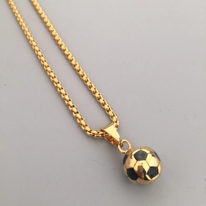 Dettaglio del ciondolo a pallone da calcio dorato con catena box e trama classica