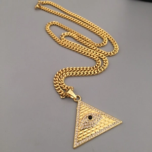 Détail d'une chaîne cubaine dorée avec pendentif pyramide œil omniscient et pierre noire