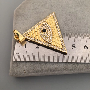 Détail du pendentif Œil de la Providence doré avec cristaux et mesure à la règle