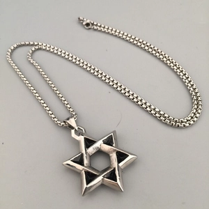 Close-up of hip hop hexagram star pendant with silver box chain on grey background