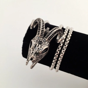 Gothic silver ram skull pendant necklace with black box chain on a display stand