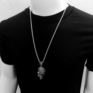 Macro shot of silver hip-hop wolf head pendant and heavy metal chain on mannequin