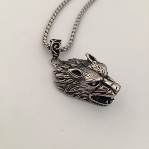 Macro detail of the vintage wolf head pendant with intricate silver fur texture