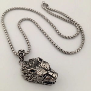 Macro detail of the roaring wolf head pendant with vintage black metal finish on a box chain