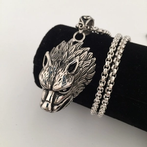 Macro shot of a heavy wolf head pendant with detailed fur texture on a silver box chain