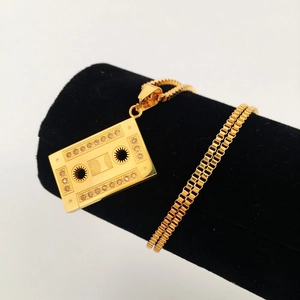 Detalle del colgante de casete dorado con cristales brillantes y cadena de estilo box