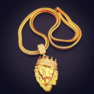 Detail of gold lion head pendant with crown and rhinestones on a thick snake chain