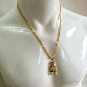 Detalle de colgante con forma de enchufe bicolor dorado y plateado estilo hip-hop urbano