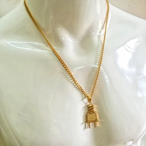 Primer plano detallado del collar con colgante de enchufe dorado hiphop en un busto