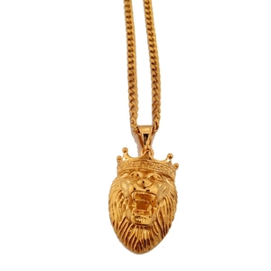 Detailed view of hip hop gold lion head pendant with crown and greca pattern details
