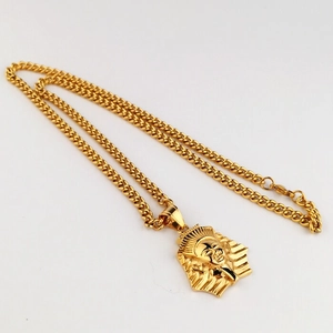Dettaglio del ciondolo a forma di faraone dorato con catena a maglie cubiche in stile hip hop