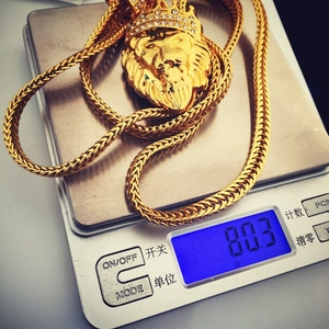 Detailed view of hip hop lion head pendant with crown showing 80.3g weight on scale