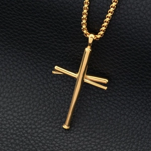 Detailed macro shot of golden baseball bat cross pendant on black leather background