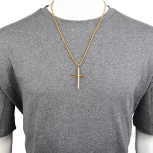 Detail shot of golden baseball bat cross pendant necklace on a male model torso