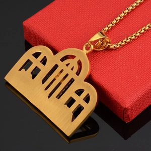 Detailed close-up of a gold-plated architectural pendant with a brushed finish on box chain