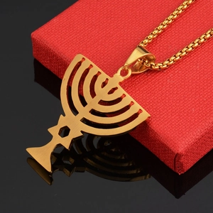 Macro detail of a golden Menorah and Star of David pendant on a box chain