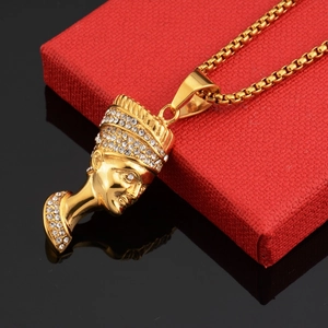 Pendentif égyptien Néfertiti doré avec strass brillants présenté sur un coffret à bijoux