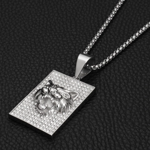 Détail macro du pendentif rectangulaire argenté serti de cristaux et tête de tigre