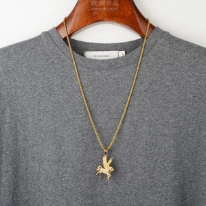 Golden Pegasus pendant necklace with sparkling crystals on a gray t-shirt display
