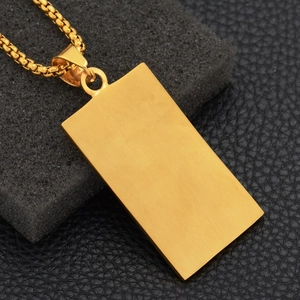 Close-up of gold rectangular pendant with brushed metal texture on a box chain