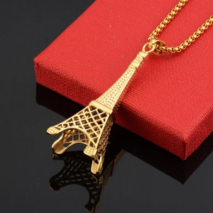 Macro shot of gold Eiffel Tower pendant necklace on red velvet box with reflection