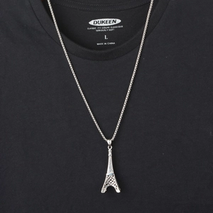 Eiffel Tower pendant necklace in silver stainless steel on a black textured background