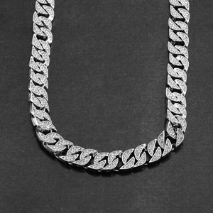 Gros plan d'un collier Hip-hop en argent avec cristaux brillants sur fond noir intense