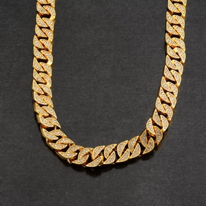 Collier hip-hop doré avec gros maillons pavés de cristaux brillants sur fond noir élégant